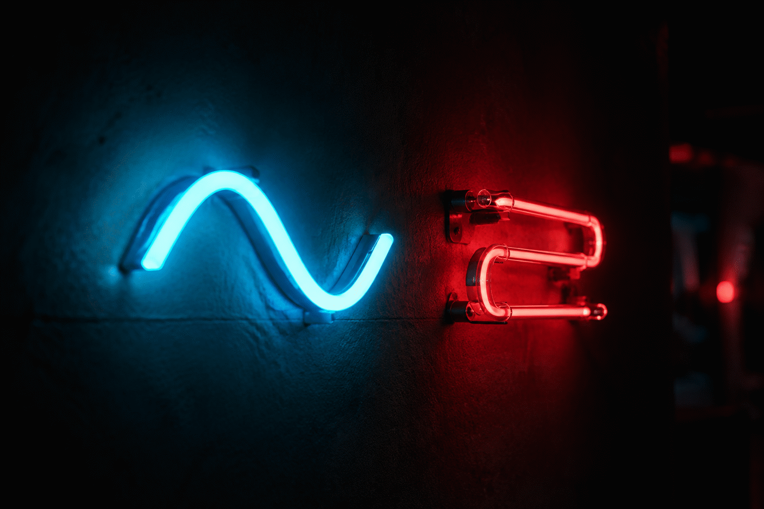 LED Neon vs Glass Neon — visual for the section “The Case for LED (Where It Wins Decisively)”: dark scene, glowing neon focal point, shallow depth of field