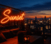 Dark scene with a glowing vivid orange neon sign reading Sunset