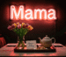 Dark scene with a glowing coral pink neon sign reading Mama