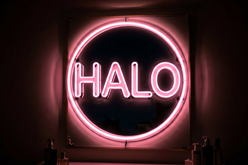 Dark scene with a glowing soft pink neon sign reading HALO