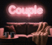 Dark scene with a glowing blush neon sign reading Couple