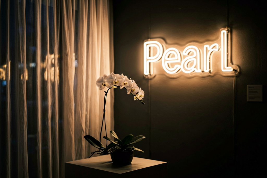 Dark scene with a glowing warm white neon sign reading Pearl